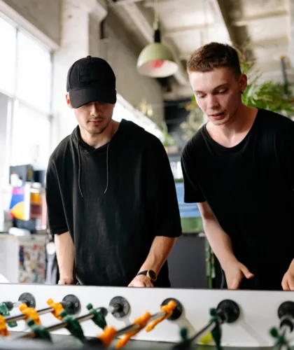 парни играют в настольный футбол