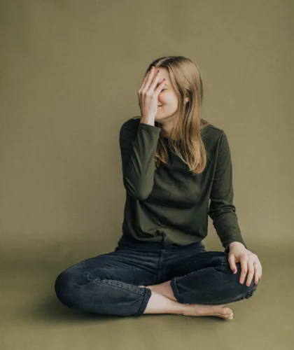 девушка закрывает лицо рукой